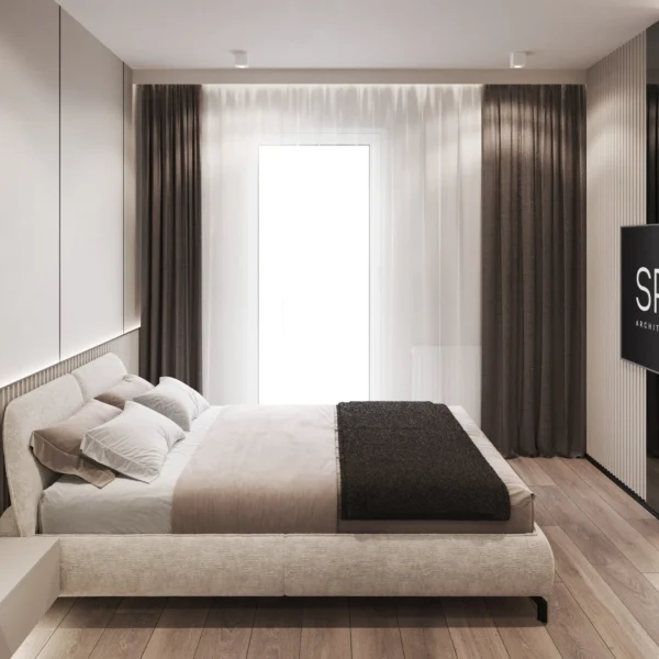 Bed with beige linen and a dark throw in a light bedroom