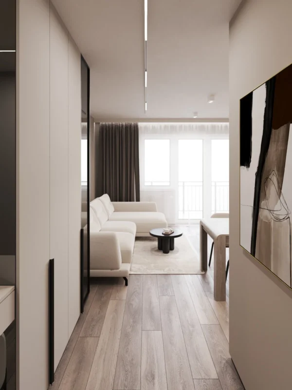View from the hall to the living room with a sofa and windows to the loggia