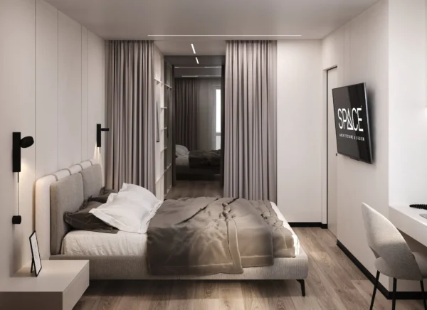 View of the bed from the workspace, black wall lights and the wardrobe mirror