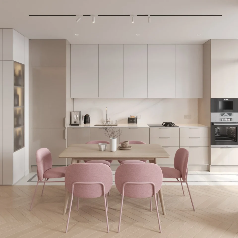 Salon z aneksem kuchennym: jadalnia z różowymi krzesłami i dębowym stołem na tle biało-beżowej kuchni