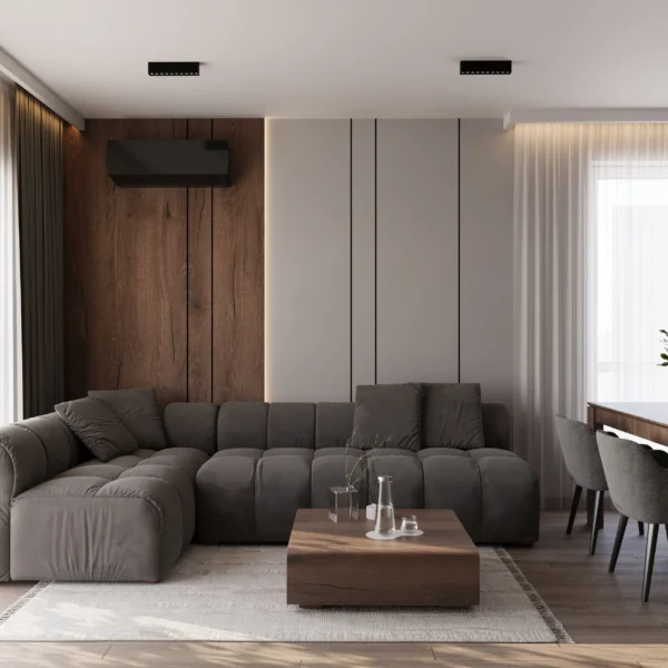 Szara sofa narożna na tle ściany z drewnianym panelem i jasnych paneli ściennych