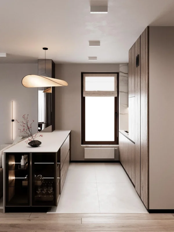 Galley kitchen along the wall, an island with a lit display cabinet and a window at the end