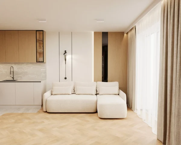 Corner sofa in the living room in front of an oak-front kitchen and a wall light
